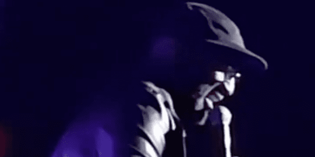 Man performing on stage with microphone.